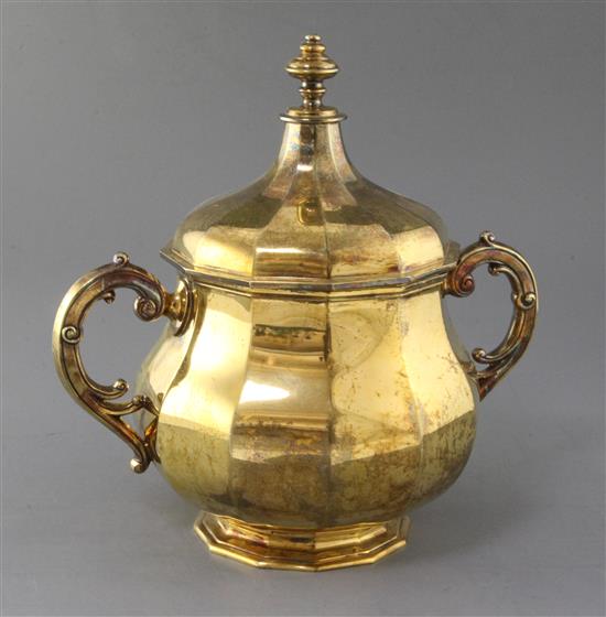 A George V silver gilt dodecagonal panelled two handled cup and cover by Thomas of New Bond Street, London, 68 oz.